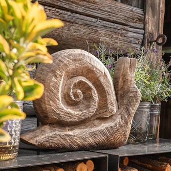 Eine aus Holz geschnitzte Schnecken-Skulptur auf einem Tisch.