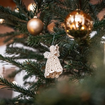 Kleines Weihnachtswunder erleben Festlich geschmückter Weihnachtsbaum mit goldenen Kugeln und Engelanhänger im Hotel im Brandnertal in Vorarlberg.