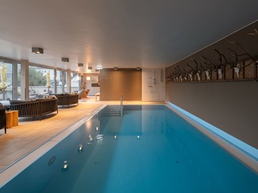 Ruhiger Indoorpool im Adults Only Wellnessbereich im Valavier in Brand mit Liegebereich und warmem Licht.
